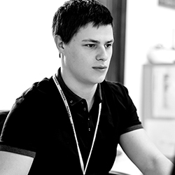 Young man in polo shirt looking at a computer screen